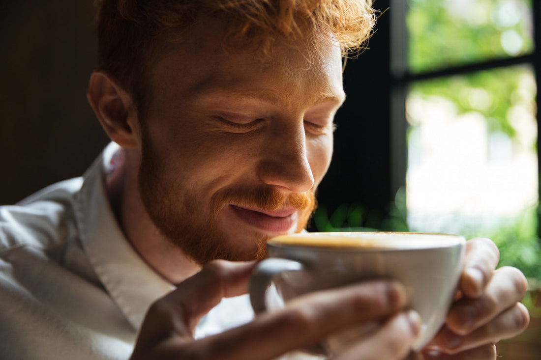 A man smells a freshly brewed cup of coffee