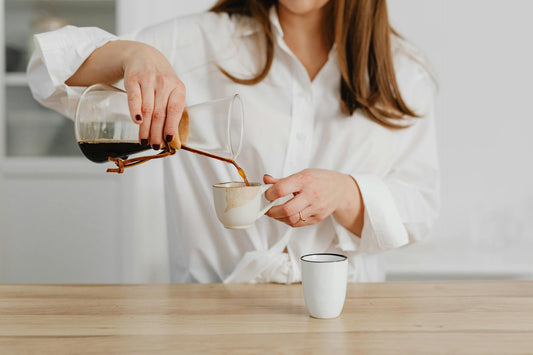 A woman pouring a cup of coffee