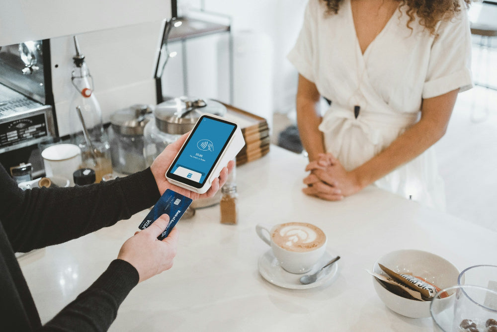 A person paying with a credit card at a coffee shop
