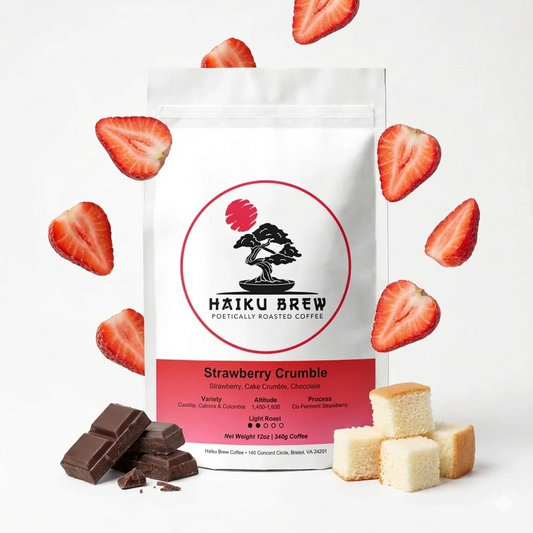 A bag of coffee titled Strawberry Crumble with slices of strawberries floating in the air around the bag and pieces of chocolate and yellow cake sitting by the bag. 